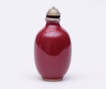 SNUFF BOTTLE ovalada em porcelana chinesa, revestida por esmalte monocromático Sangue de boi. Tampa em vidro, com colar preto e colher. Séc. XIX. Alt. 8,0 cm.