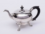 ELEGANTE E RARO BULE piriforme para chá, em prata inglesa repuxada e cinzelada, do reinado de George II (1727 - 1760 ), ornamentado por estilizações florais e geométricas. Bojo liso, encimado por larga faixa finamente incisa com folhagens, volutas e adornos, que se estende em parte sobre a tampa, esta, plana e levemente abobadada com pega em pião. Bico recurvo moldado e ornado com gomos. Alça lateral em madeira com base revestida por folhagem. Pernas curvilíneas e filetadas, realçadas por concheados e rematadas por pés esparramados e lobulados. Contrastes de Londres de 1749 e marca do famoso prateiro Fuller White, encarregado da manutenção das pratarias do Palácio de Kensington, residência oficial do rei George II. Peça de coleção. Peso: 730 gr. (Possui duas mossas). Med: Alt. 16,7cm, Comp.(do bico à alça) 25cm, Larg.(frente) 14,5cm.