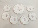 JOGO COMPOSTO POR 6 PRATOS DE SOBREMESA  E 1 PRATO DE BOLO EM PORCELANA SCHMIDT S. CATARINA COM DECORAÇÃO FLORAL E FRISO ROSA, DESGASTE NO FRISO. MEDIDA. PRATO DE SOBREMESA 17 CM D, PRATO DE BOLO 26,5 CM D