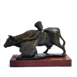 TORQUATO BASSI. Escultura de bronze representando figura feminina segurando boi. Altura 28 cm., comp