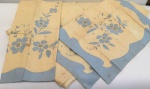 Jogo de cama de casal contendo 3 peças: lençol de cobrir de linho branco com aplicações e bordados florais no tom azul e 2 fronhas na mesma padronagem (amarelados e manchas do tempo de guardados).