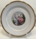 Porcelana Real- Grande prato decorativo em porcelana branca, com bordas decoradas em ouro e cena central com figura de damas e cupido. Medindo 32 cm de diâmetro. Lindíssmo!