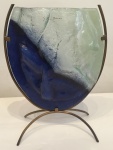 Elegante vaso de vidro moldado no tom azul e translucido com contornos irregulares, assinado, apoiado sobre base de metal dourado, medindo: 35 cm alt. x 21 cm larg.
