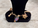 Pulseira em ouro baixo com berloques diversos (jarra, figa, peixe articulado, entre outros adornos)