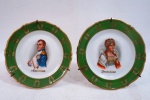 Par de pratos decorativos para coleção em porcelana francesa da manufatura de "Limoges" pintados a mão com detalhes em relevo, ricamente policromados, decorados com busto do Imperador "Napoleão" e "Josephine", borda movimentada na cor verde com decoração e frisos à folha de ouro. Acompanha suporte de parede. Med. 15 cm de diâmetro.