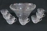 Poncheira em vidro prensado translucido lavrado por flores em relevos composto por poncheira, sete canecas. Total 08 peças. Medidas: Poncheira  16 cm alt x 32cm de diâmetro, caneca 9 cm de diâmetro.