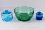 Três peças em vidro, sendo dois baleiros no tom azul e uma saladeira na cor verde decorada em gomos. Med. baleiros 11 cm x 12 cm, 9 cm x 18 cm, saladeira 11 cm altura x 22 cm diâmetro.