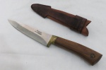Faca em lâmina de aço Germany, marca Rodeio, punho de madeira, acompanha bainha de couro. Med. 25 cm.