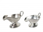 <b>METAL PRATEADO</b>, lote com duas (2) molheiras confeccionadas em metal espessurado da marca WOLFF, sendo: A) 1 cinzelada por caneluras, fitas cruzadas e rosinhas, medindo 11x19x8,5cm e B) 1 cinzelada por caneluras e fitas cruzadas, medindo 9,5x19,5x9cm.