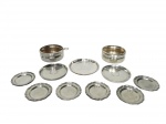 <b>METAL PRATEADO e ESTANHO</b>, lote com onze (11) peças, sendo: A) 2 porta garrafas em metal espessurado, 1 faltando suporte para tampa, ambos não possuem tampa, medindo 5x14,5x11,5cm, falhas no banho, B) 2 porta garrafas e 6 pequenos pratinhos em estanho JOHN SOMERS, maior peça medindo 12cm e menor 8,5cm e C) 1 pequena salva confeccionada em metal espessurado da marca WOLFF, medindo 13cm.