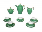 <b>PORCELANA MAUÁ</b>, uma (1) parte de serviço para café confeccionada em porcelana nacional esmaltada na tonalidade verde, filetes e realces em ouro, apresentando excelente estado de conservação, sendo: A) 1 bule para café, medindo 17,5x16,5x9cm, B) 1 açucareiro, medindo 10,5x12,5x7cm, C) 1 leiteira, medindo 11x11x5,5cm e D) 5 xícaras para café com seus respectivos pires, medindo 4x8,5x6,5cm.
