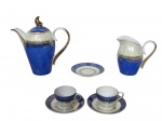 PORCELANA SCHMIDT - (3) Peças confeccionadas em porcelana esmaltada em furta cor e na tonalidade azul , decorada por elementos florais em douração , alças e bordas filetadas em ouro , sendo (A) - bule para café , medida : 11,5 cm  , (B) - uma leiteira , med : 11 cm e (C) duas xícaras , med : 4,5 cm