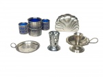 <b>METAL PRATEADO</b>, lote com cinco (5) peças confecciondas em metal espessurada a prata de modelos, tamanhos e decorações distintas, sendo: A) 1 paliteiro, medindo 6x4cm, B) 1 porta copo, medindo 10x8,5cm, C) 1 palmatória, medindo 6x11x8,5cm, D) 1 porta guardanapos, medindo 8x10x4cm e E) 1 floreira com 3 recipientes em vidro na tonalidade azul cobalto, medindo 7x14x6cm.