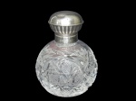 <b>PRATA e CRISTAL</b>, um (1) perfumeiro confeccionado em cristal europeu translucido com lapidação de caneluras, pingos de diamante, palmas e losangos em baixo relevo, tampa em PRATA DE LEI contrastada 925mls, apresentando pequena mossa, medindo 10cm de altura.