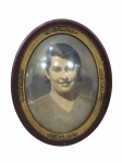 <b>FOTOGRAFIA</b>, uma (1) fotografia antiga emoldurada em madeira com pintura marrom, caneluras e elementos florais em douração, vidro convexo, necessitando reparo na tampa traseira, medindo 29x23cm.