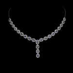 Majestoso colar em prata de lei espessurada a ouro branco, design moderno exclusivo de excepcional ourivesaria com preciosa cravação de Tanzanitas extra de 4.0 x 3.0 mm, clássica lapidação oval brilhante, adornadas por rico trabalho e belas coroas de Zirconias extra brancas com fino acabamento. Perfeito estado de conservação, sem uso. Mede aprox 51 cm de comprimento, pingente 3,5 cm. Origem Tanzânia e África.