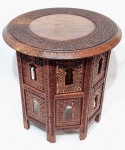 ÍNDIA - Belíssima e clássica mesa Indiana, finamente construída a mão em pesada e antiga madeira típica de lei, ricamente decorada com belíssima ornamentação floral, incrustação de metal dourado e riquíssimo acabamento fenestrado. Índia, meados do Século XX. Excelente estado de conservação. Mede 54,0 cm de altura x 54,0 cm de diâmetro do tampo.