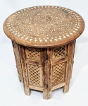 ÍNDIA - Belíssima e clássica mesa Indiana, finamente construída a mão em antiga madeira típica patinada, ricamente decorada com belíssima ornamentação floral, incrustação de metal dourado e riquíssimo acabamento fenestrado. Índia, meados do Século XX. Excelente estado de conservação. Mede 38,0 cm de altura x 38,0 cm de diâmetro do tampo. 