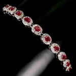 Majestosa pulseira em prata de lei espessurada a ouro branco, design moderno exclusivo de excepcional ourivesaria com preciosa cravação de Rubis de 4.0 x 3.0 mm, clássica lapidação oval brilhante, adornadas por rico trabalho e bela coroa de Zirconias extra brancas com fino acabamento. Perfeito estado de conservação, sem uso . mede 21 cm de comprimento x 0,6 cm de largura. Origem Madagascar, África.