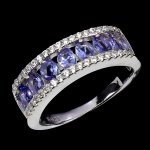 CLÁSSICO ANEL MEIA ALIANÇA EM PRATA DE LEI ESPESSURADA A OURO BRANCO, DESIGN EXCLUSIVO DE EXCEPCIONAL OURIVESARIA COM PRECIOSA CRAVAÇÃO DE TANZANITAS DE 4.0 X 3.0 MM, CLÁSSICA LAPIDAÇÃO OVAL BRILHANTE, ADORNADAS POR RICO TRABALHO E FINO ACABAMENTO COM ZIRCONIAS EXTRA BRANCAS. PERFEITO ESTADO DE CONSERVAÇÃO, SEM USO. ARO MEDE 1,8 CM, ARMAÇÃO 2,2 X 0,6 CM. ORIGEM TANZÂNIA.