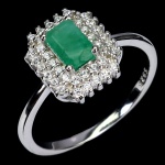 Belíssimo anel em prata de lei espessurada a ouro branco, design moderno exclusivo com preciosa Esmeralda de 6.0 x 4.0 mm, clássica lapidação octogonal brilhante, adornada por rico trabalho, fino acabamento e majestosas coroas de Zirconias extra brancas com fino acabamento. Perfeito estado de conservação, sem uso. Aro mede 1,8 cm, armação 1,0 x 1,2 cm. Origem Colômbia. Possui incisões naturais.