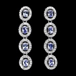Belíssimo Par de Brincos em prata de lei espessurada a ouro branco, design moderno exclusivo de excepcional ourivesaria com majestosa cravação de Tanzanitas de 4.0 e 3.0 mm, clássica lapidação oval brilhante, adornadas por rico trabalho e fino acabamento com elegantes coroas de Zirconias extra. Perfeito estado de conservação, sem uso. medem aprox 3,4 x 0,6 cm . origem Tanzânia.