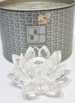 SWAROVSKI - Impecável e belíssima escultura/castiçal em cristal de tonalidade translúcida, representando rara e linda flor de lótus, riquíssima lapidação com extraordinária luminescência. Acondicionado em estojo original, selado sobre a base. Áustria, meados de 1980. Perfeito estado de conservação. Mede 5,5 x 9,5 x 9,5 cm aproximadamente.