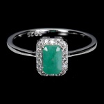 Belíssimo Anel em prata de lei espessurada a ouro branco, design moderno exclusivo com preciosa Esmeralda de 6.0 x 4.0 mm, clássica lapidação octogonal brilhante, adornada por rico trabalho, fino acabamento e majestosa coroa de Zirconias extra brancos com fino acabamento. Perfeito estado de conservação, sem uso. Aro mede 1,8 cm, armação 0,6 x 0,8 cm. Origem Colômbia. Possui inclusões naturais. OBS: FORMA CONJUNTO COM OS LOTES Nº 446, 447 E 448.