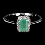 Belíssimo Anel em prata de lei espessurada a ouro branco, design moderno exclusivo com preciosa Esmeralda de 6.0 x 4.0 mm, clássica lapidação octogonal brilhante, adornada por rico trabalho, fino acabamento e majestosa coroa de Zirconias extra brancos com fino acabamento. Perfeito estado de conservação, sem uso. Aro mede 1,8 cm, armação 0,6 x 0,8 cm. Origem Zâmbia. Possui inclusões naturais.