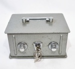Caixa cofre feita em metal de ótima fundição, dupla senha e chave central. Bom estado de conservação. Mede 9,5 cm de altura x 14,5 x 19,0 cm das laterais.