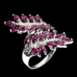 MAGNIFICO ANEL EM PRATA DE LEI ESPESSURADA A OURO BRANCO, DESIGN MODERNO EXCLUSIVO DE EXCEPCIONAL OURIVESARIA COM PRECIOSA CRAVAÇÃO DE GRANADAS RODOLITA DE 5.0 X 2.5 MM, CLÁSSICA LAPIDAÇÃO MARQUISE BRILHANTE, ADORNADAS POR RICO TRABALHO E FINO ACABAMENTO. PERFEITO ESTADO DE CONSERVAÇÃO, SEM USO. ARO MEDE 2,0 CM, ARMAÇÃO 3,4 X 2,0 CM. ORIGEM MOÇAMBIQUE.