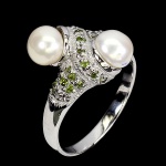 Charmoso anel em prata de lei espessurada a ouro branco, design moderno exclusivo com belas Pérolas de 7.0 mm, adornadas por rico trabalho e fino acabamento com incrustação de Chrome Diopside. Perfeito estado de conservação, sem uso. Aro mede 1,8 cm. Origem Tailândia e Rússia.