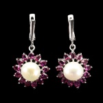 Belíssimo par de brincos em prata de lei espessurada a ouro branco, design moderno exclusivo de excepcional ourivesaria com linda pérola barroca de 10 mm, adornada por rico trabalho e fino acabamento com majestosa coroa de Granadas Rodolitas de 4.0 x 3.0 mm clássica lapidação oval brilhante. Perfeito estado de conservação, sem uso. Medem 3,6 x 1,8 cm. Origem Tailândia e África.