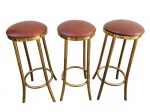 LOTE COMPOSTO POR TRÊS ELEGANTES BANQUETAS EM METAL DOURADO DE EXCELENTE FUNDIÇÃO COM ASSENTO GIRATÓRIO E ESTOFADO EM COURO. CONJUNTO EM ÓTIMO ESTADO DE CONSERVAÇÃO, ESTRUTURA FIRME E COURO PRESERVADO. MEDEM APROX 74 CM DE ALTURA X 30 CM DE DIÂMETRO, CADA.