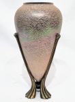 Elegante e lindo vaso, executado em vidro artístico iridescente de ótima qualidade e manufatura. Design moderno e exclusivo, apoiado sobre base de metal de boa fundição. Perfeito estado de conservação. Mede 33,5 cm de altura x 9,0 cm de diâmetro do círculo da borda.