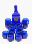 Lindo e antigo jogo de botelha e 12 copos, feitos em vidrão artístico de tonalidade azul cobalto. Bom estado de conservação. Botelha mede 26,5 cm de altura x 10,0 cm de diâmetro da base, 4 copos medindo 5,5 cm de altura x 4,0 cm de diâmetro da borda, 4 medindo 6,5 x 5,5 cm e 4 medindo 7,5 x 7,0 cm.
