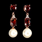 Belo par de brincos em prata espessurada a ouro rose, design moderno exclusivo de excepcional ourivesaria com linda Pérola de 7.0 mm, adornada por rico trabalho e preciosas Granadas Rodolita de 7.0 x 5.0 mm cada, clássicas lapidações pera e oval brilhante. Perfeito estado de conservação, sem uso. Medem aprox 2,8 x 0,8 cm . origem Tailândia e Moçambique.
