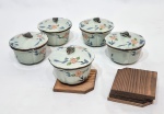 Raro e lindo lote composto por 5 compoteiras, ambas executadas em porcelana adornada por rico motivo floral. Acompanha 5 apoios em madeira. Bom estado de conservação, acondicionadas em caixa original. Medem 7,0 cm de altura x 10,0 cm de diâmetro da borda.