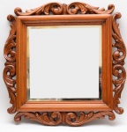 Espelho emoldurado em madeira nobre entalhada, vidro em cristal bisotado. Medidas: 75 x 75cm.