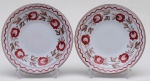 Par de pratos rasos em cerâmica esmaltada e vitrificada na cor branca, com decoração floral. Apresentam pequeno bicada no borda. Diâmetro: 23,5cm.
