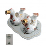 Galheteiro em porcelana Vista Alegre representando patos  com presentoir decorados com policromia e dourado sobre  fundo verde água, 22 x 6,  Alt. 11, Com.15 cm.