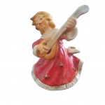 Caixa de música em porcelana alemã policromada representando anjo tocando guitarra, e na saia castiçal para uma vela, by Goebel Weihnacht, Alt. 17, Diam. 14 cm.