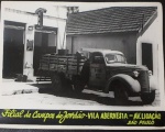Fotografia em preto e branco de Vila Abernesia em Campos do Jordão São Paulo Pitoresca fachada de comércio de época com caminhão estacionado. Med.18,5cm x 24cm.