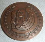 Medalha em Bronze com figura de anjo segurando uma tocha em alto relevo adornada com folhagens.  Diam. 50mm