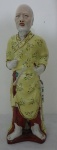 Estatueta de Porcelana representando figura oriental em trajes típicos. Alt. 25cm.