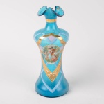 Vaso azul em vidro decorado com  casal e anjo, boca gomada, aplicações douradas, altura 20 cm.