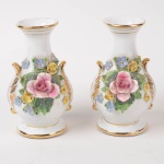 Par de graciosos vasos em porcelana na cor branca com aplicação de flores policromadas em relevo e círculos dourados, altura 16 cm.
