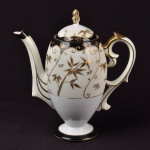 Bule para chá em porcelana europeia, na cor branca decorada com detalhes em dourado e azul cobalto, altura 23 cm.