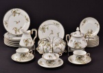 Parte de aparelho para chá em porcelana, composto por: 11 pratos par abolo, 1 cremeira, 11 xícaras para chá , 1 manteigueira, 11 pires, 1 açucareiro.