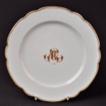 Prato raso em porcelana francesa com a letra C entrelaçada em dourado, 21 cm de diâmetro.